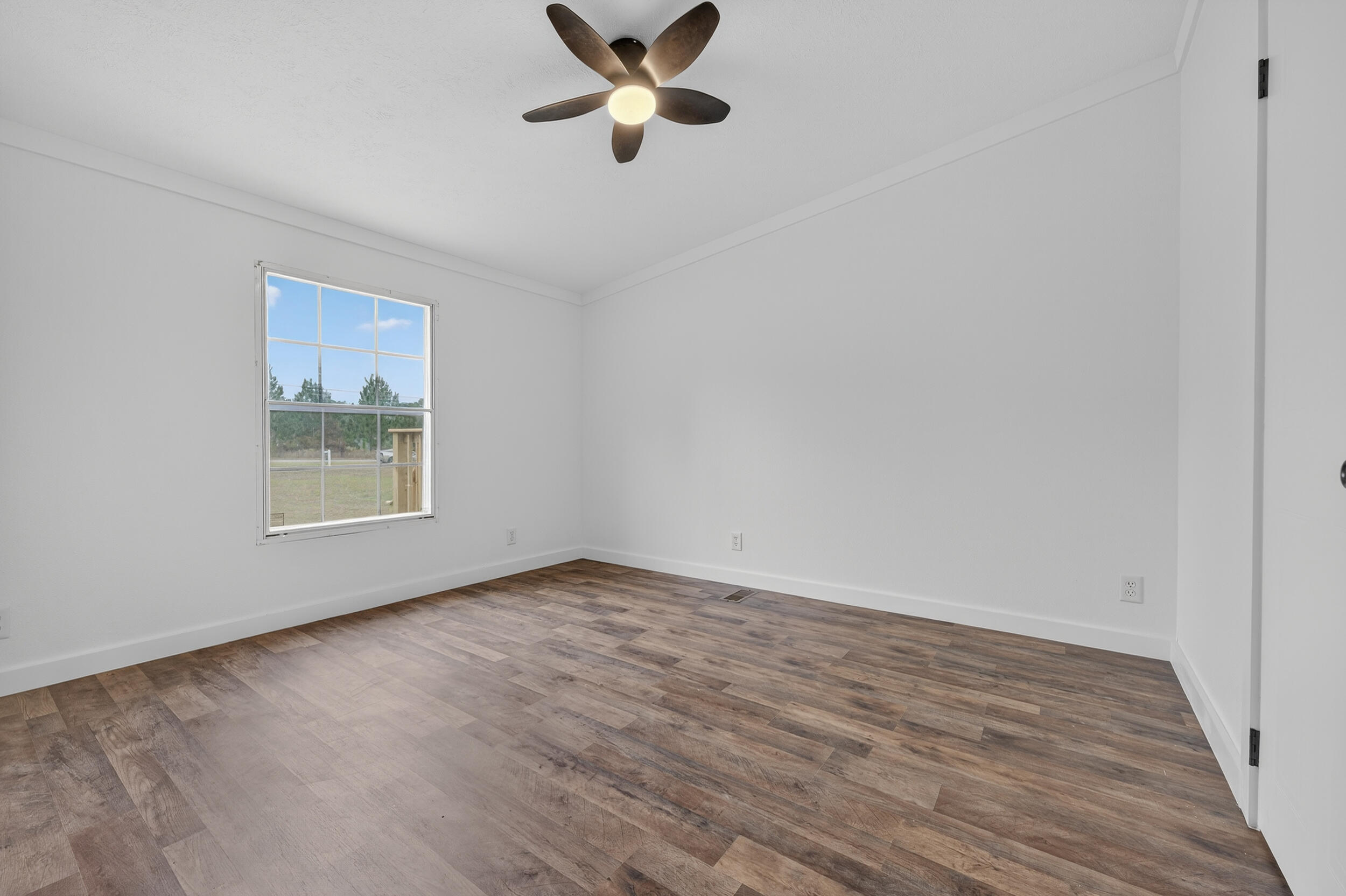 4580 Rainbird Rise Road Crestview, FL 32539 - Photo 29 of 41 a view of an empty room with wooden floor and a window