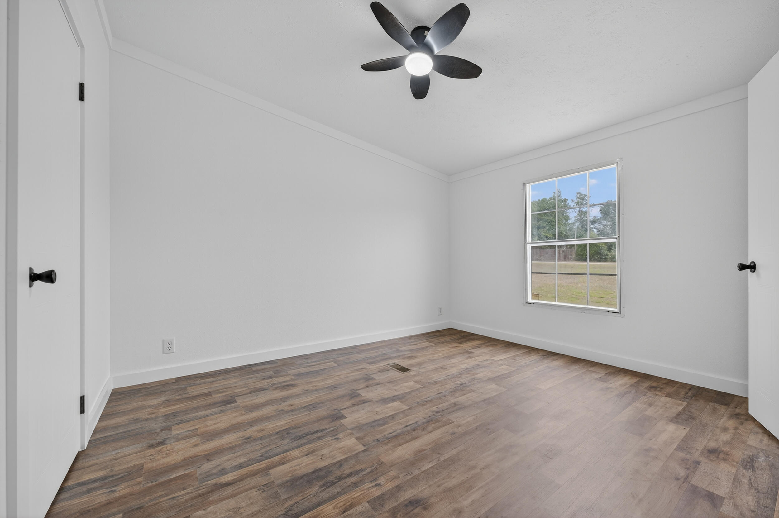 4580 Rainbird Rise Road Crestview, FL 32539 - Photo 35 of 41 an empty room with wooden floor fan and windows