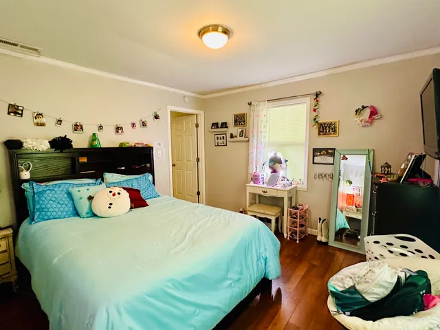a bedroom with a bed and wooden floor