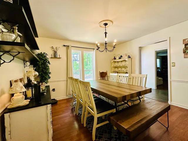 a dining room with furniture potted plants and wooden floor