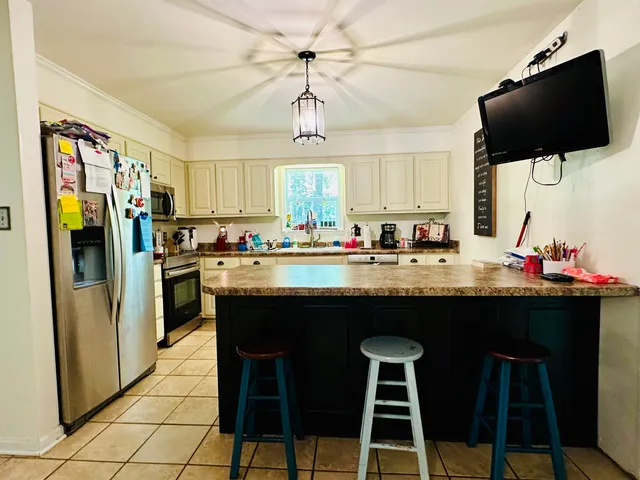 a kitchen with stainless steel appliances granite countertop a stove a refrigerator a sink and a refrigerator