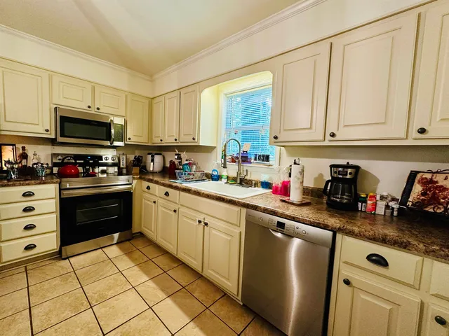 a kitchen with granite countertop a sink stainless steel appliances and cabinets
