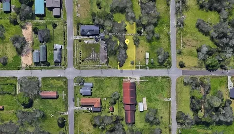 an aerial view of a house with a yard and large trees