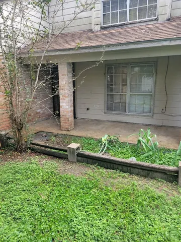 a front view of a house with a yard and potted plants