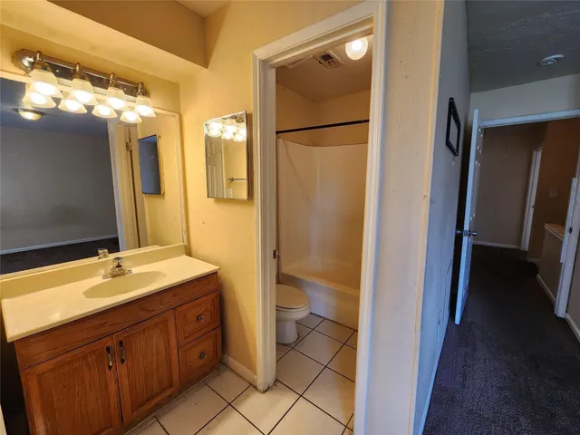 a bathroom with a granite countertop sink mirror and a bathtub