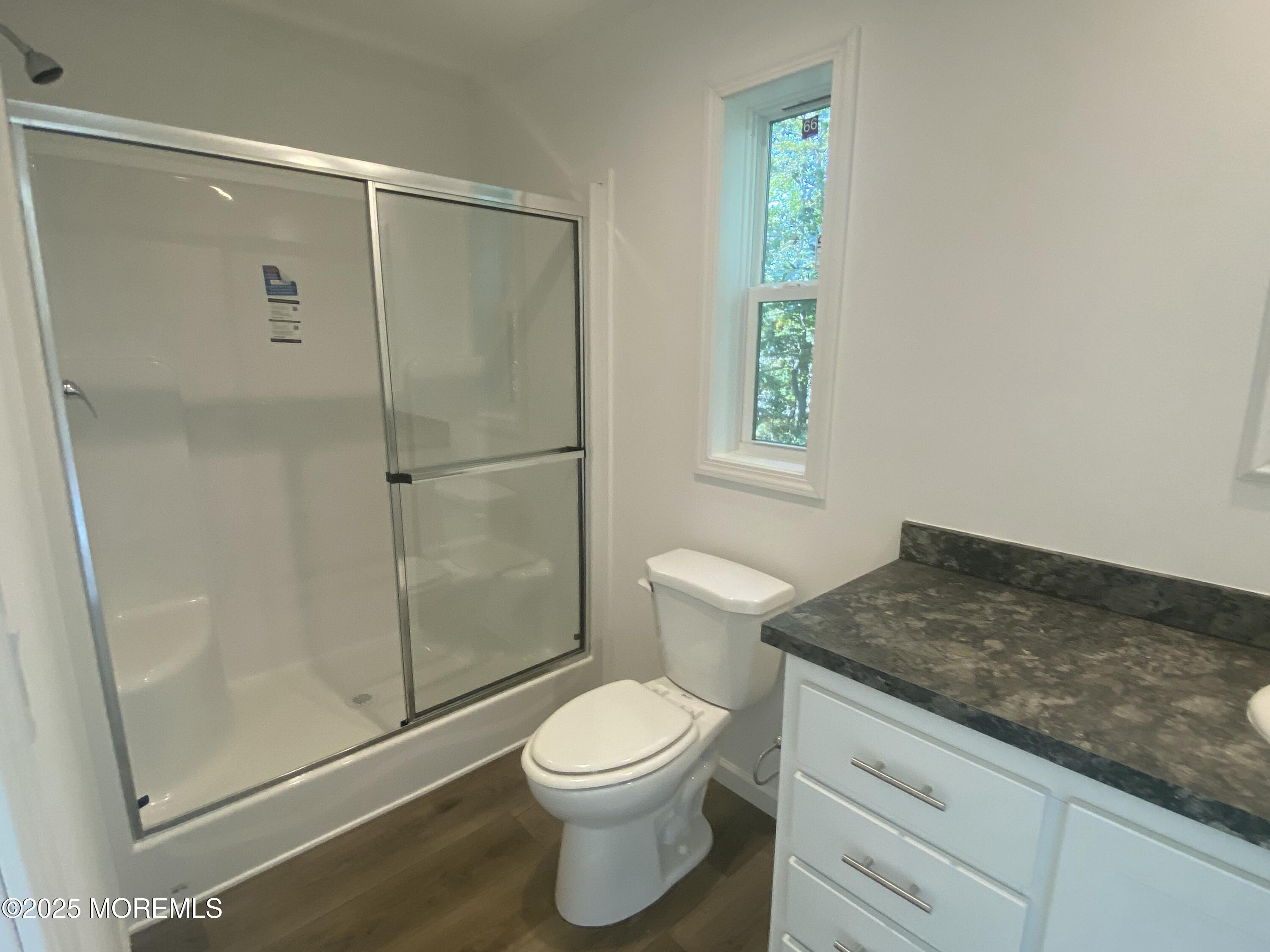 18 Maple Tree Court Manahawkin, NJ 08050 - Photo 13 of 21 a bathroom with a granite countertop toilet a sink a shower and a window