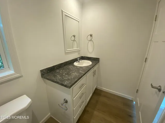 a bathroom with a granite countertop sink and a mirror