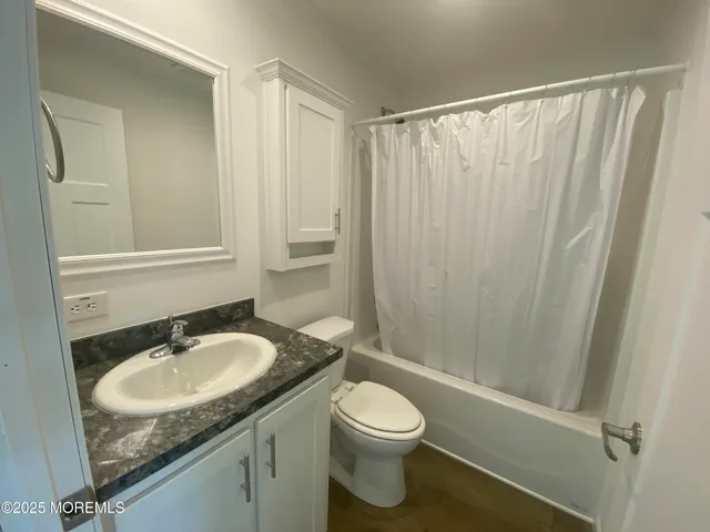 a bathroom with a granite countertop sink toilet and shower