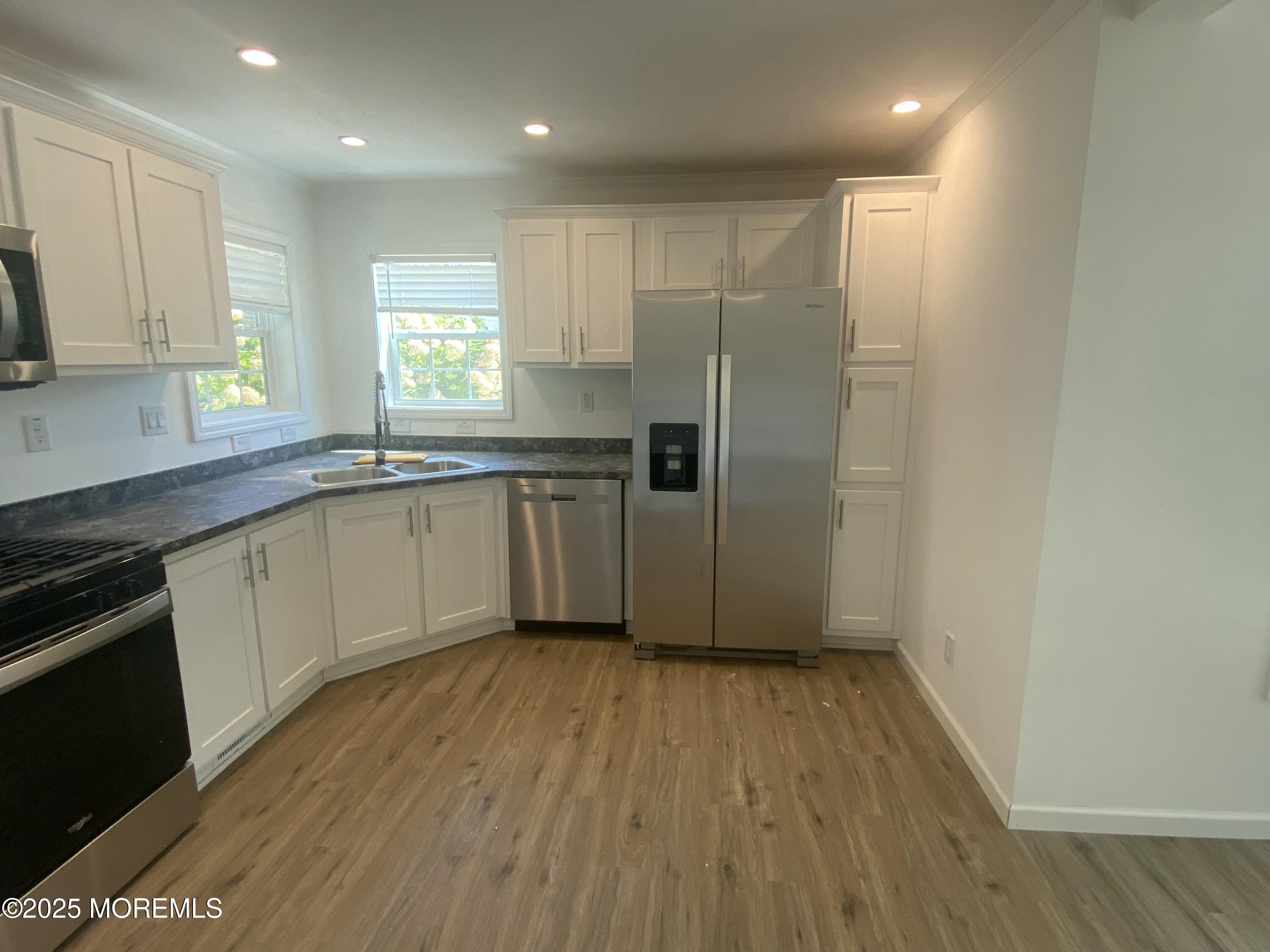 18 Maple Tree Court Manahawkin, NJ 08050 - Photo 4 of 21 a kitchen with stainless steel appliances granite countertop a refrigerator a sink and white cabinets with wooden floor