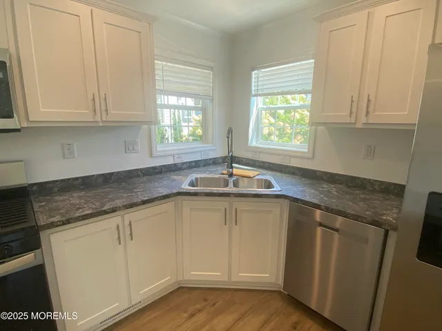 a kitchen with granite countertop white cabinets and a sink