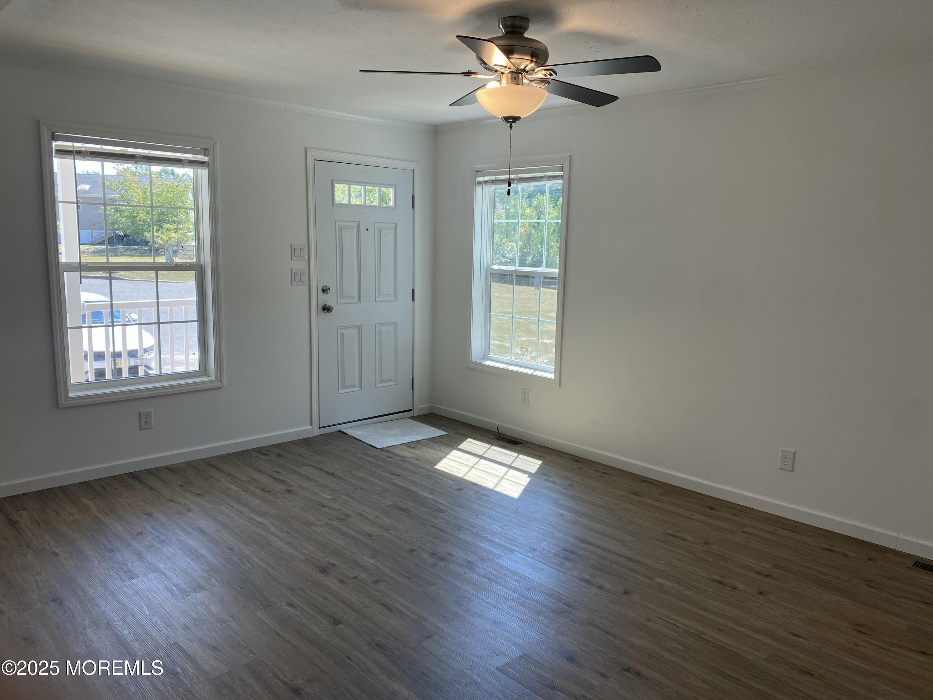 18 Maple Tree Court Manahawkin, NJ 08050 - Photo 8 of 21 a view of an empty room with a window and wooden floor