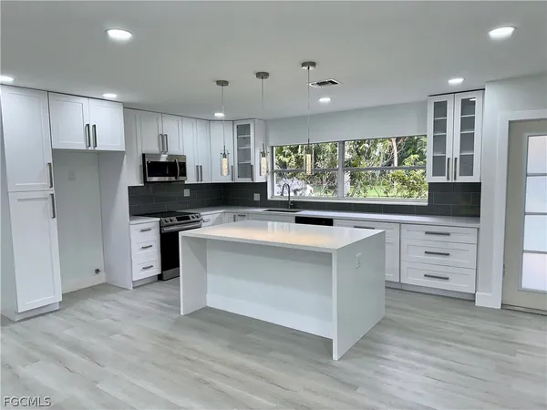 a kitchen with stainless steel appliances a stove top oven and a refrigerator