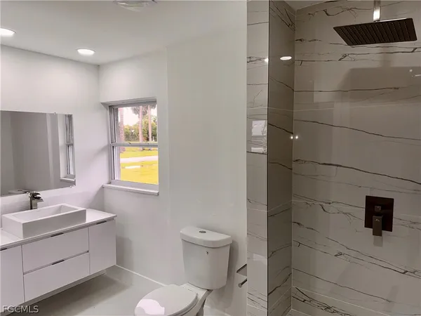 a bathroom with a sink a toilet and shower