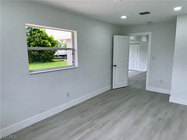 an empty room with wooden floor and a window