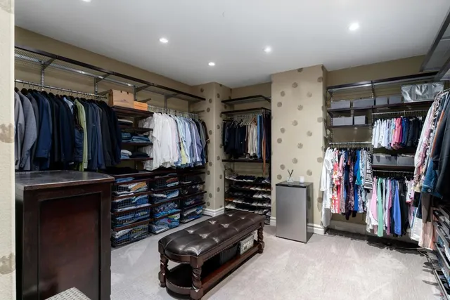 a view of walk in closet with clothes and shoes