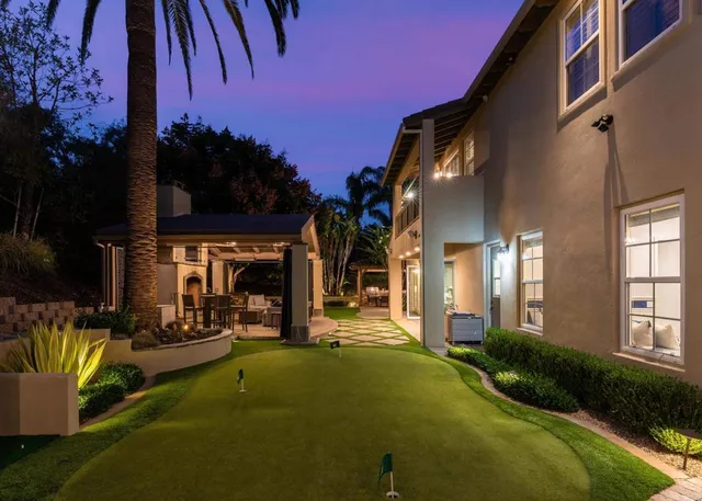 a kitchen with stainless steel appliances granite countertop a stove a sink dishwasher a dining table and chairs with wooden floor