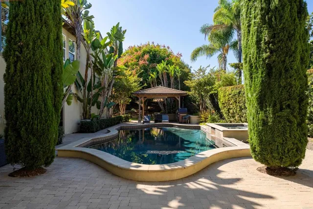 a view of a patio with table and chairs potted plants and large tree