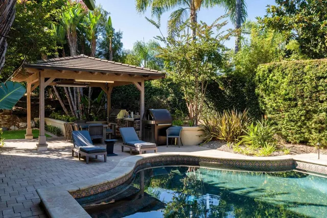 a view of a house with backyard and sitting area