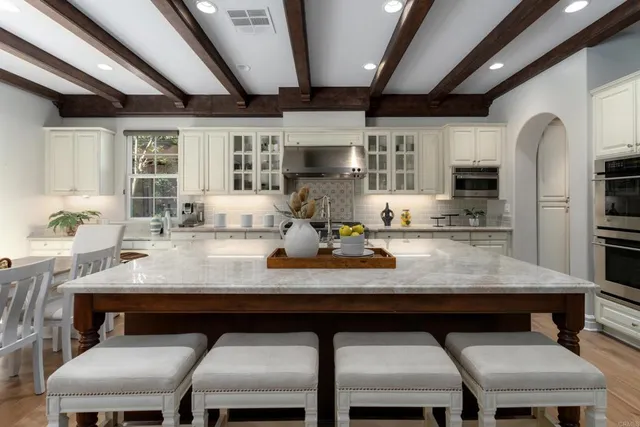 a kitchen with a dining table chairs cabinets and stainless steel appliances