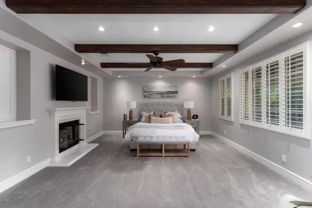 a spacious bedroom with a bed tv and a fireplace