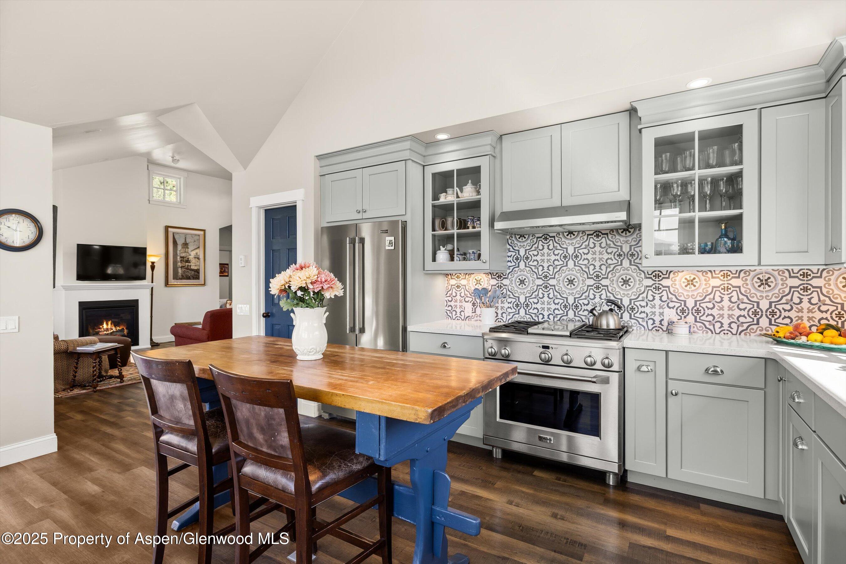 148 Gateway Road Snowmass, CO 81654 - Photo 3 of 32 a kitchen with stainless steel appliances granite countertop a stove a sink dishwasher a dining table and chairs with wooden floor