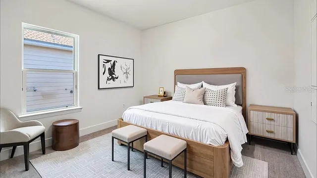 a bedroom with a bed a table and a window