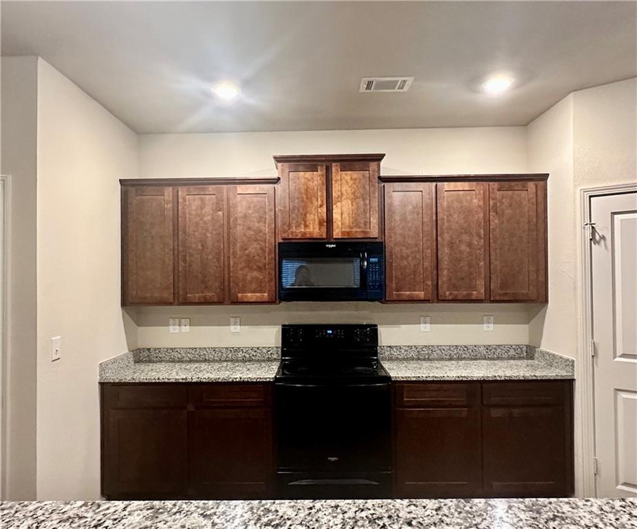 916 Independence Avenue Pendergrass, GA 30567 - Photo 8 of 30 a view of a kitchen with granite countertop white cabinets and black appliances