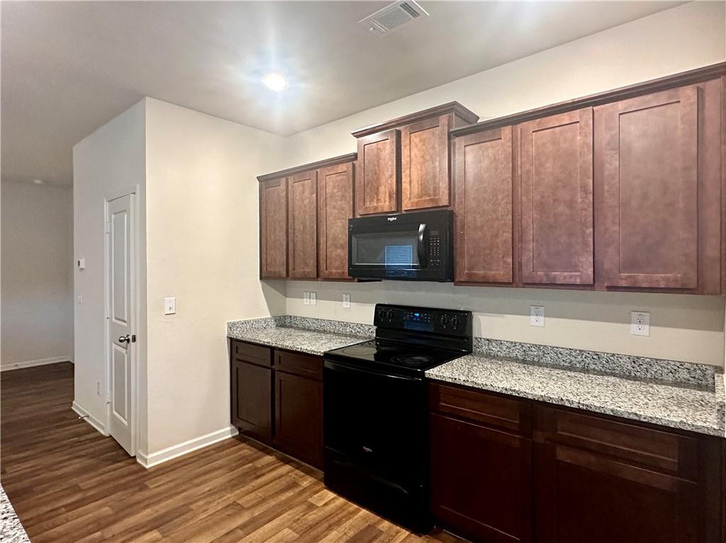 916 Independence Avenue Pendergrass, GA 30567 - Photo 9 of 30 a kitchen with stainless steel appliances granite countertop a stove a sink and a microwave