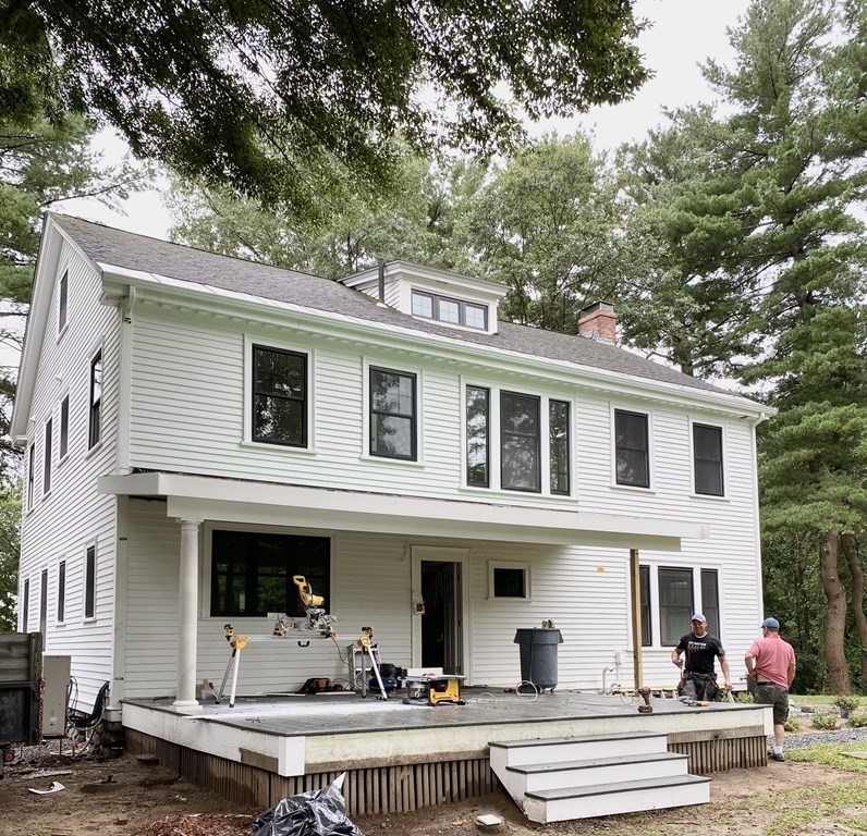 270 Concord Road Wayland, MA 01778 - Photo 6 of 9 a view of a white house with a fountain and a large tree