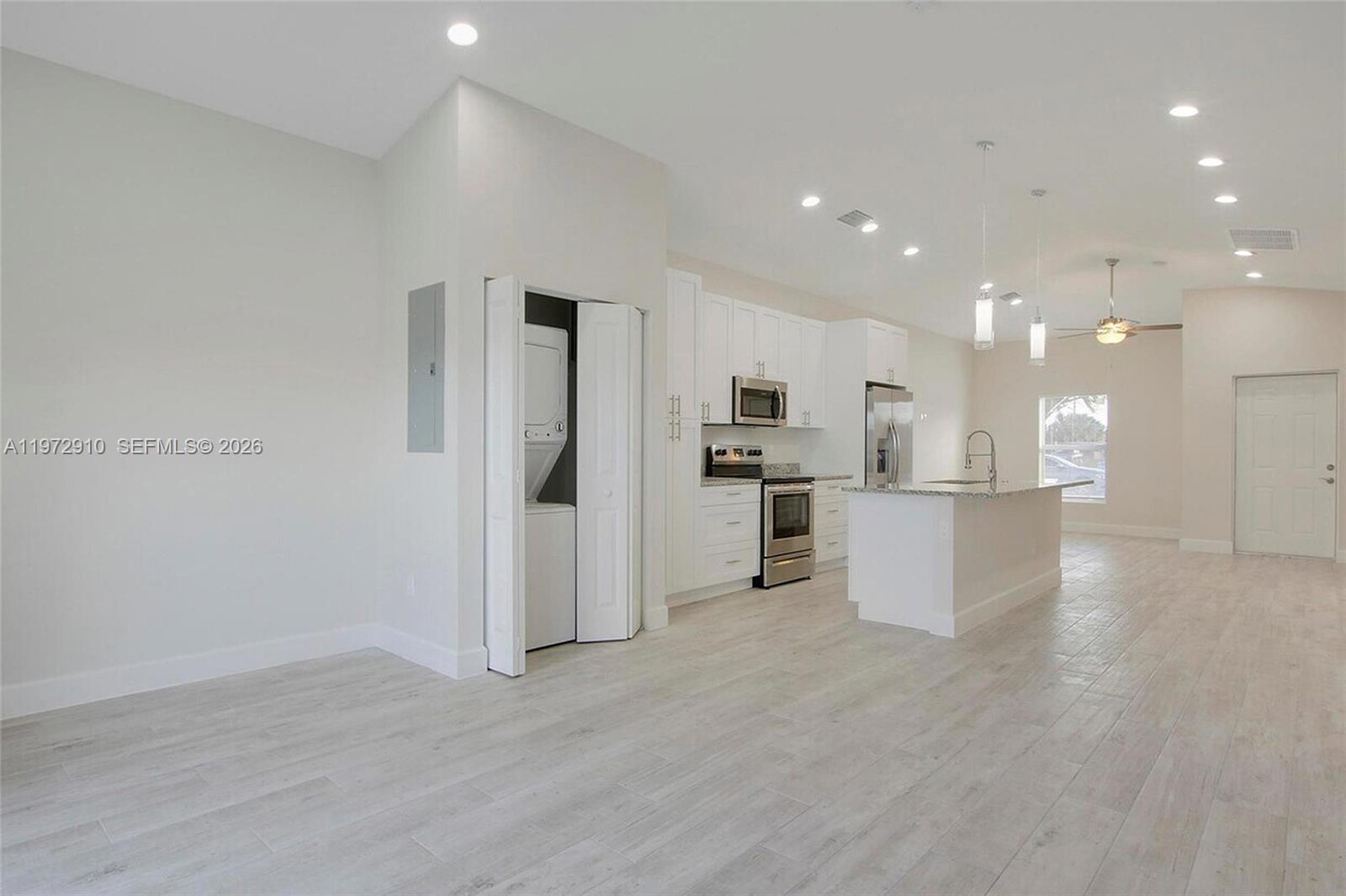 1546 West 26th Court Riviera Beach, FL 33404 - Photo 5 of 13 a view of kitchen view refrigerator and white cabinets