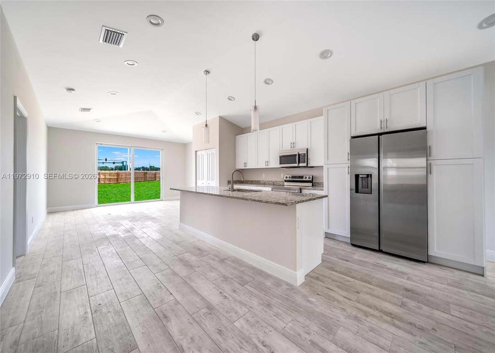 1546 West 26th Court Riviera Beach, FL 33404 - Photo 6 of 13 a kitchen with stainless steel appliances granite countertop a refrigerator and a stove
