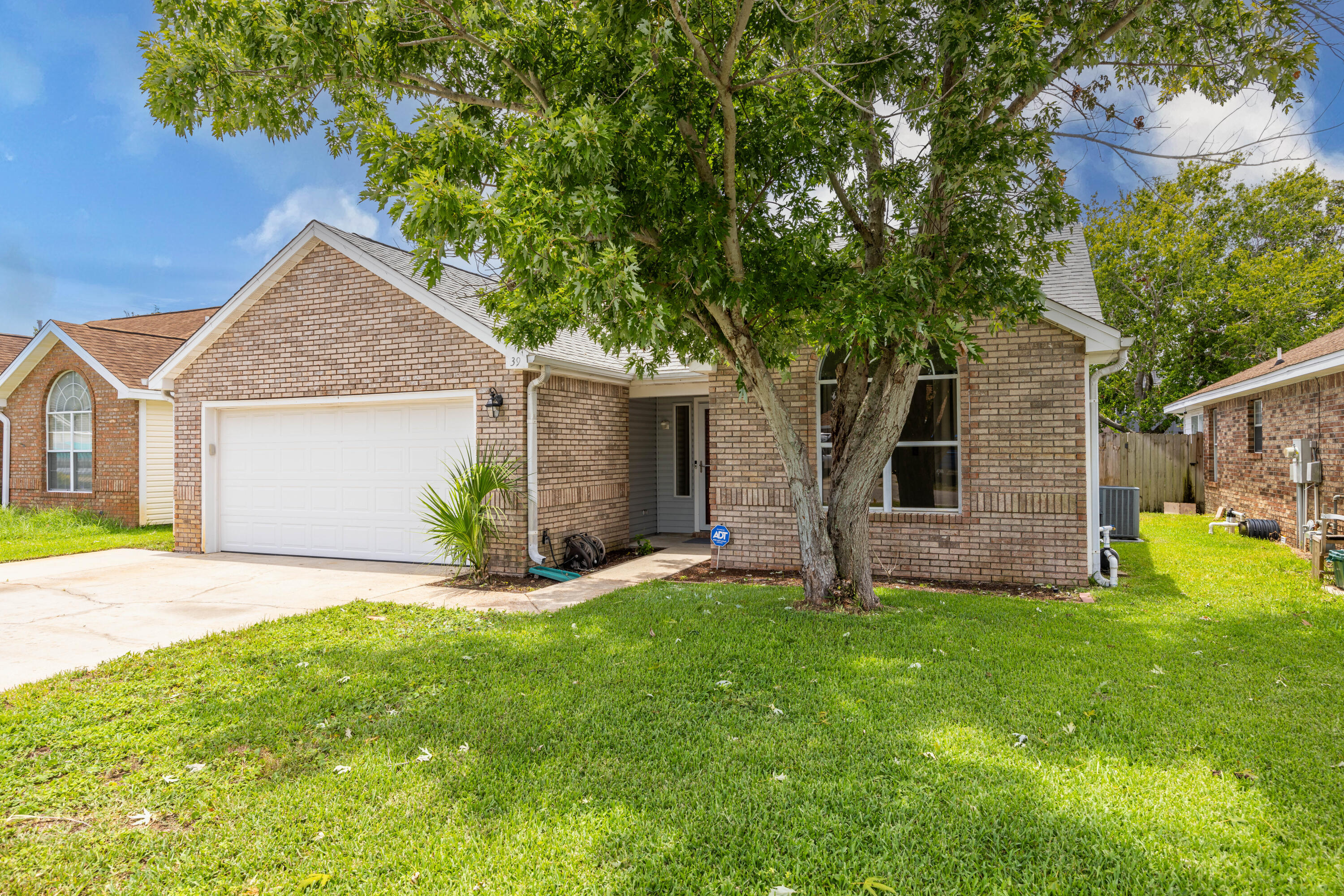 a view of a house with a yard and tree