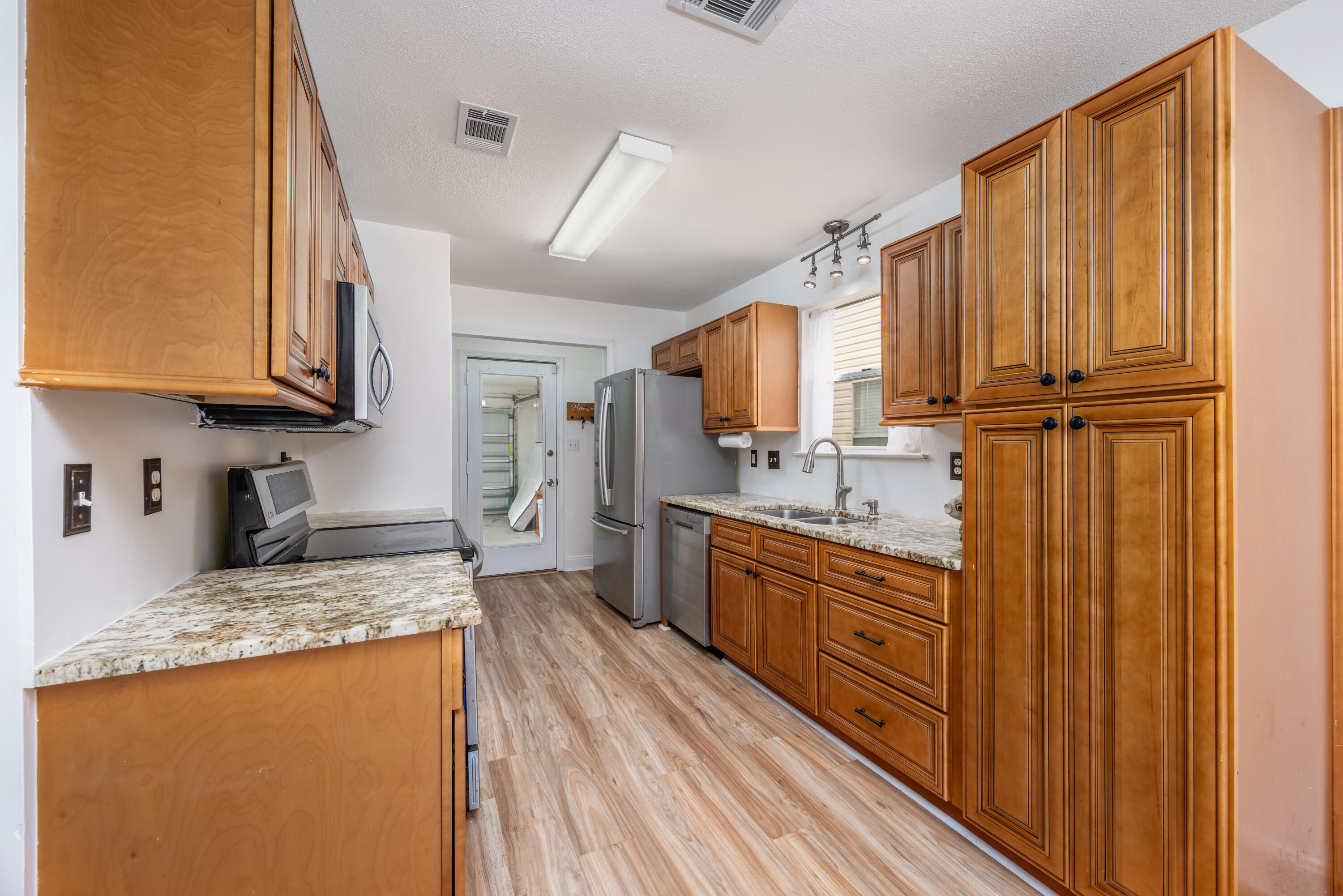 39 Pine Ridge Trace Destin, FL 32541 - Photo 8 of 42 a kitchen with granite countertop wooden cabinets stainless steel appliances a sink and a window