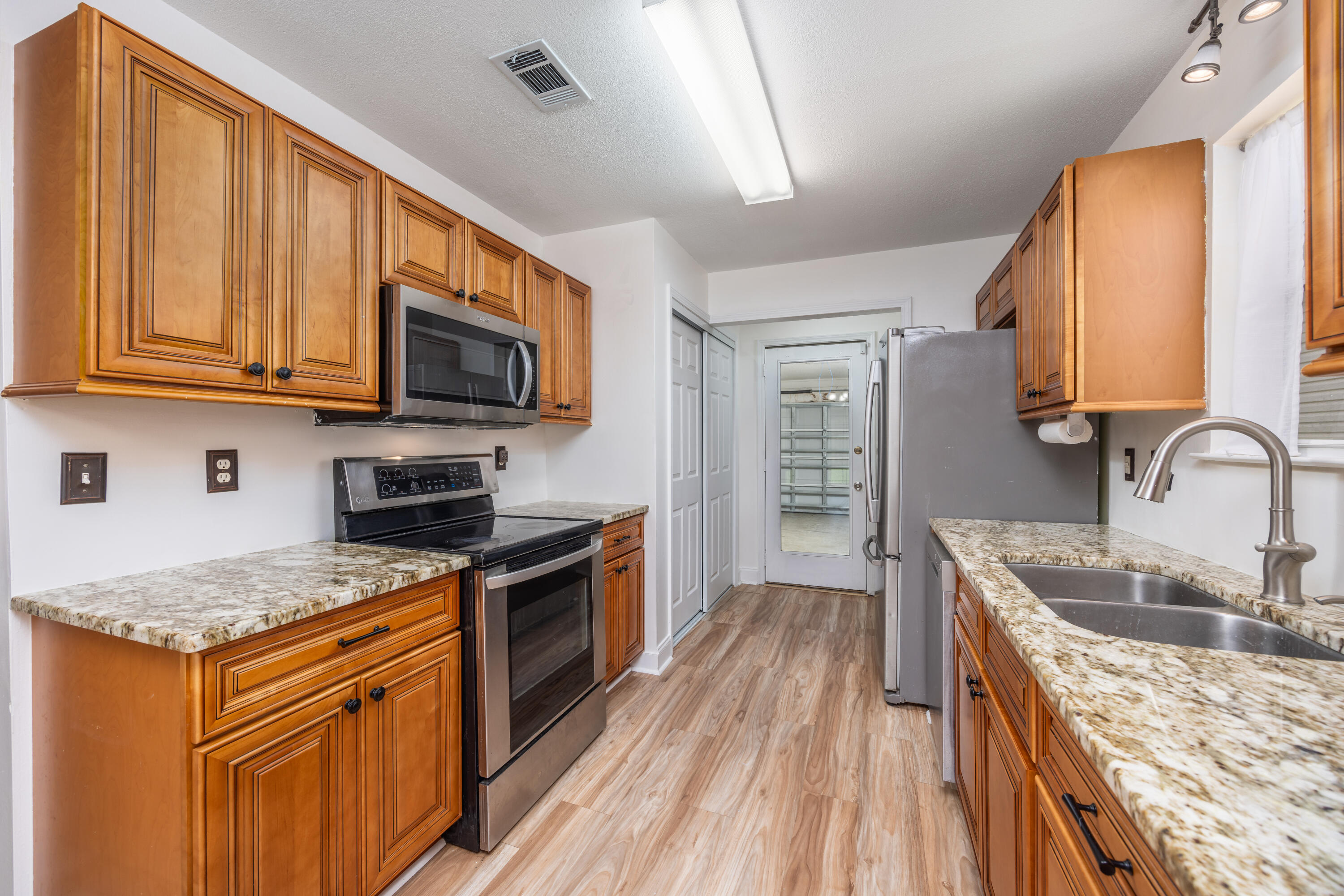 39 Pine Ridge Trace Destin, FL 32541 - Photo 9 of 42 a kitchen with granite countertop wooden cabinets stainless steel appliances and a sink