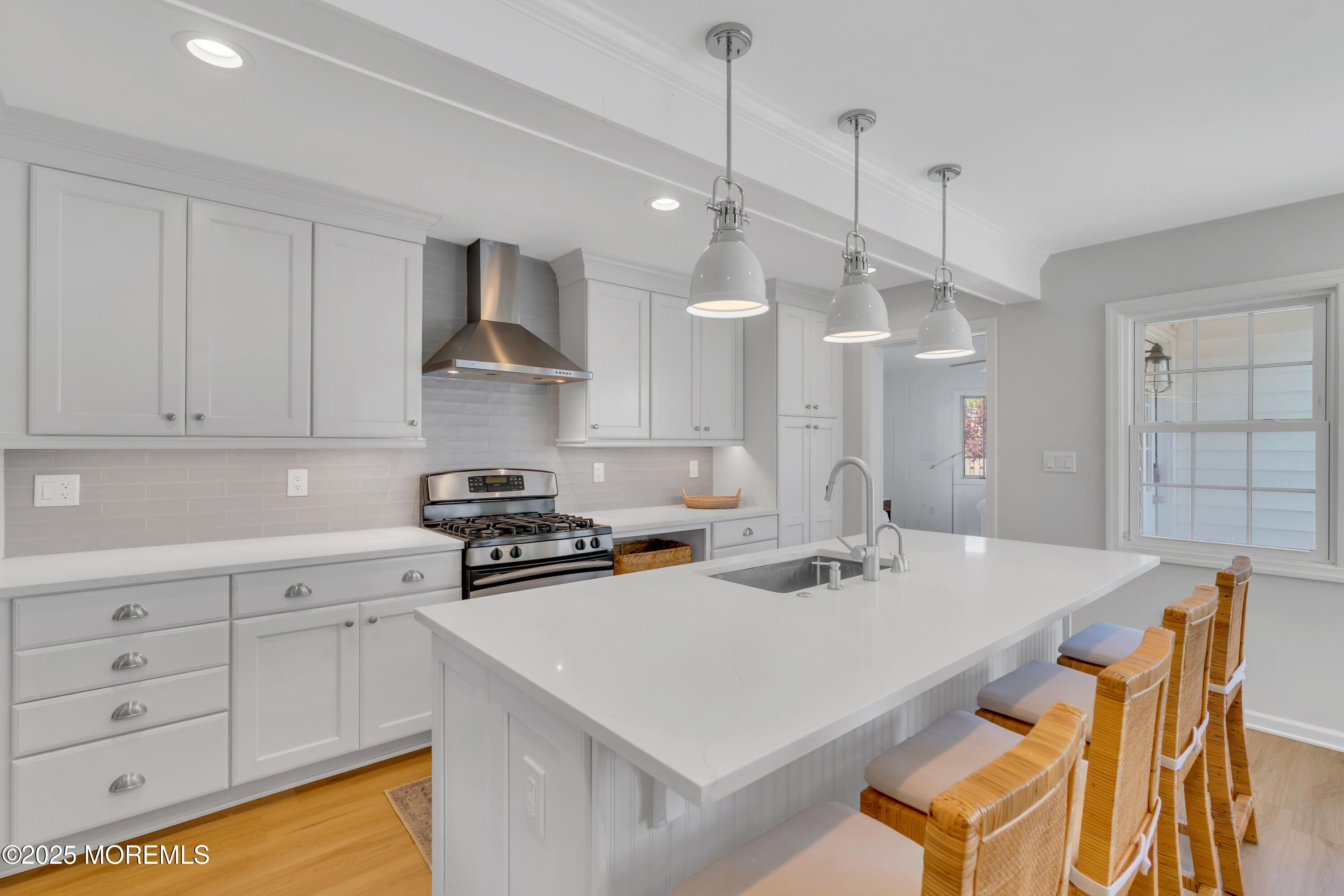 312 Woodland Road Point Pleasant Beach, NJ 08742 - Photo 11 of 52 a kitchen that has a stove a sink a dining table and chairs with white wooden cabinets