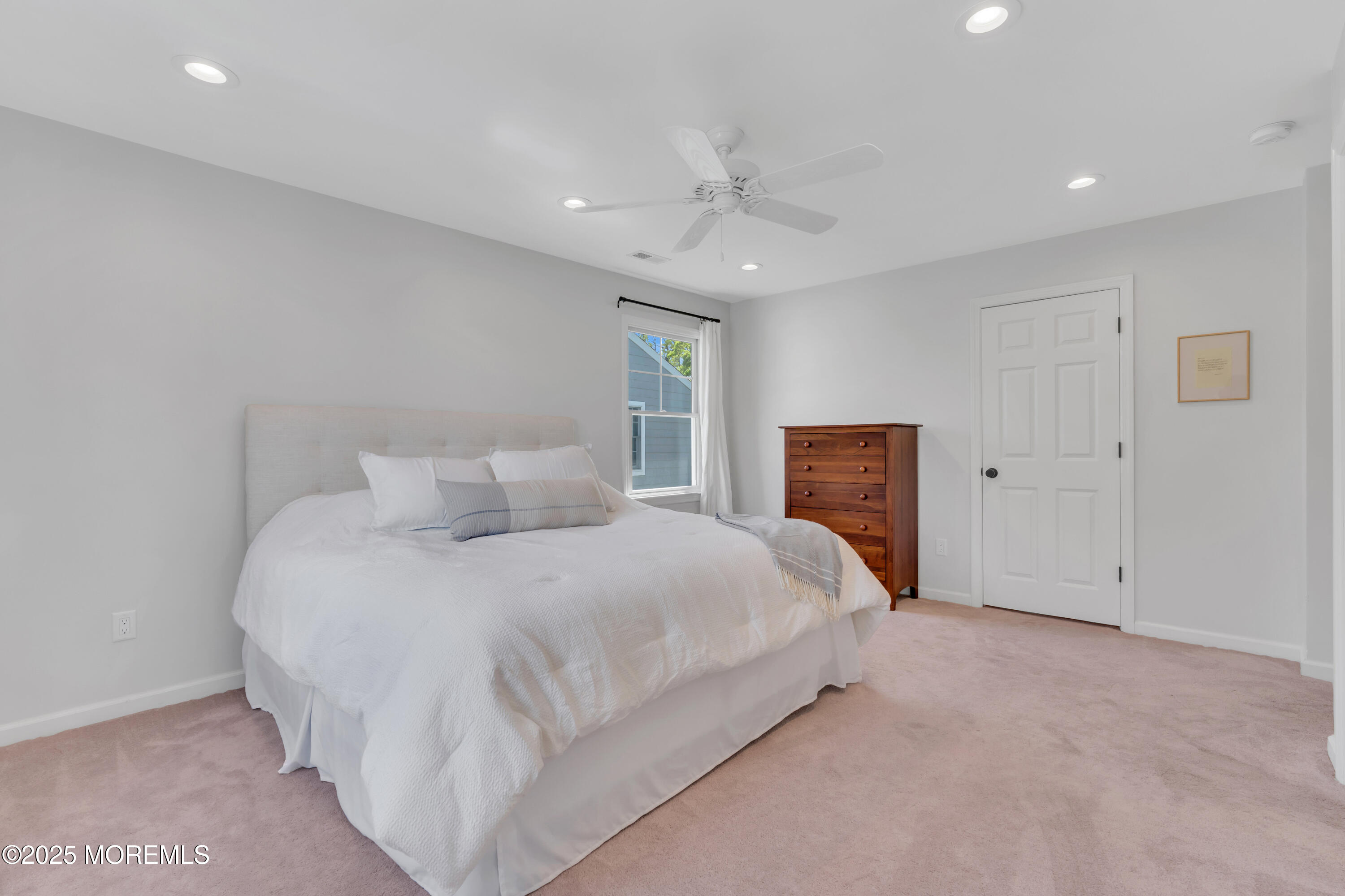 312 Woodland Road Point Pleasant Beach, NJ 08742 - Photo 16 of 52 a large bed sitting in a room next to a ceiling window and a flat screen tv