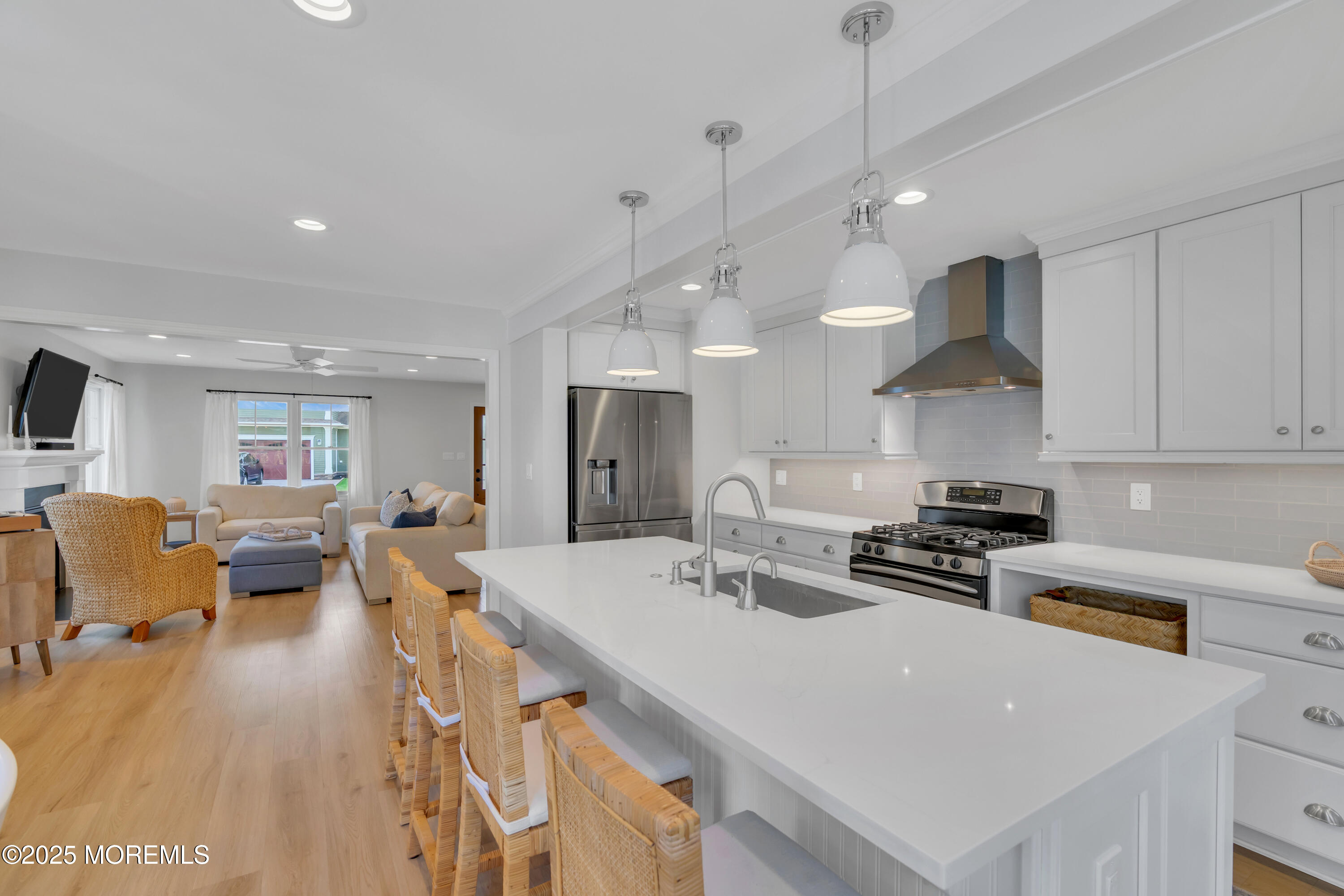 312 Woodland Road Point Pleasant Beach, NJ 08742 - Photo 9 of 52 a large kitchen with stainless steel appliances a stove a sink a dining table and chairs with wooden floor