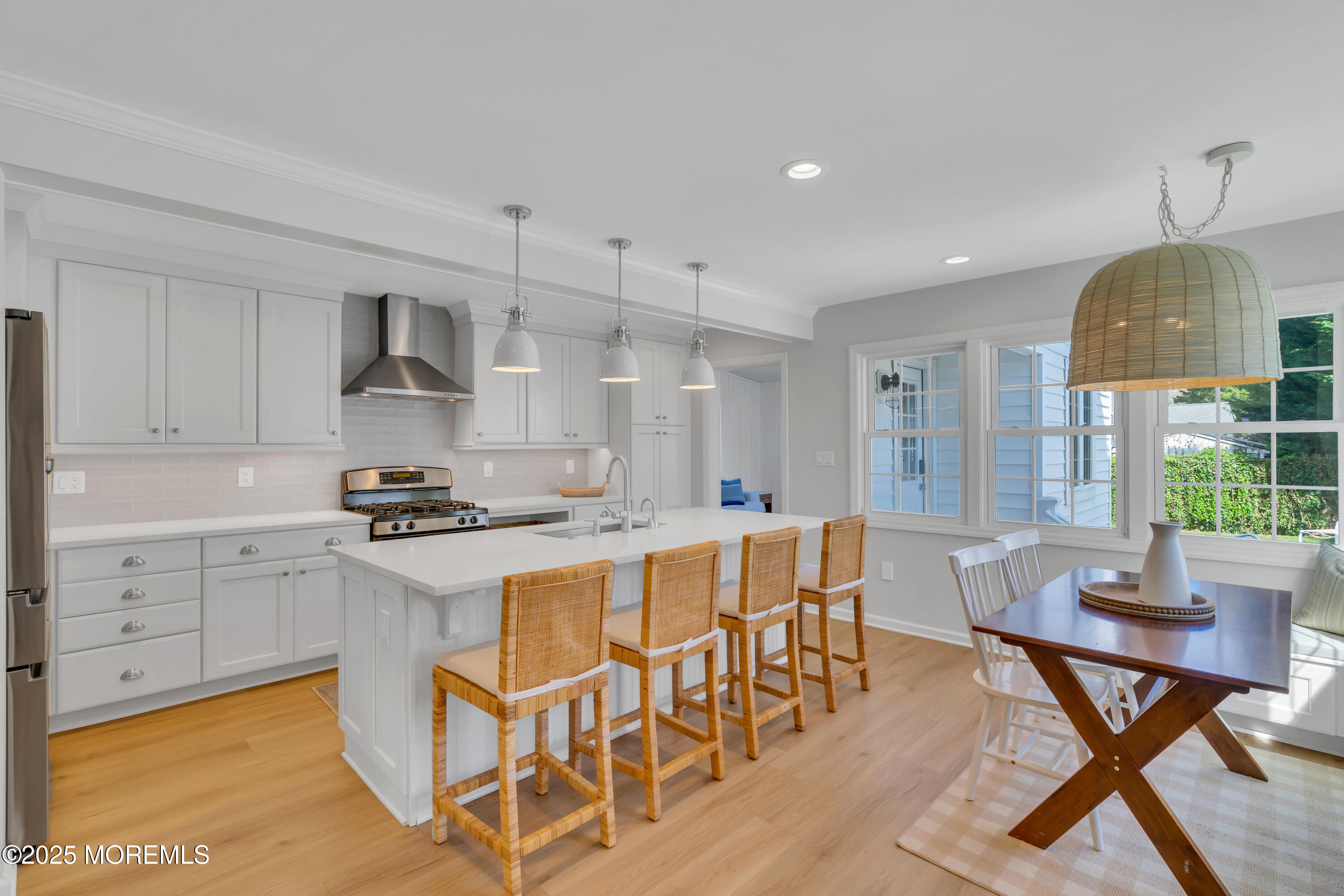 312 Woodland Road Point Pleasant Beach, NJ 08742 - Photo 10 of 52 a kitchen with stainless steel appliances granite countertop a stove a sink dishwasher a dining table and chairs with wooden floor