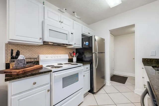 a living room with furniture a flat screen tv and a window