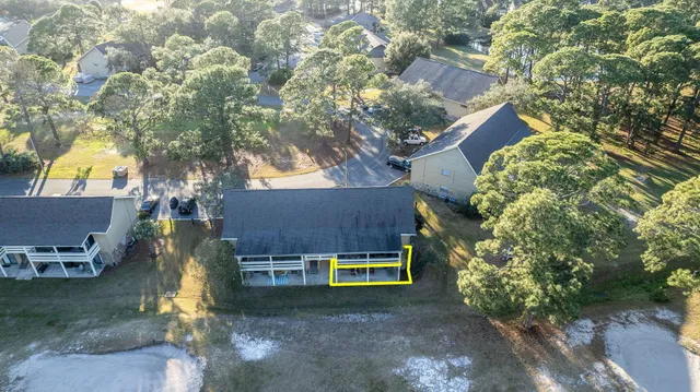 a view of a house with a yard and large tree
