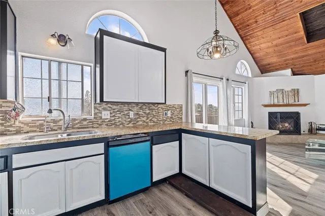 a hall with kitchen island granite countertop a sink and a stove