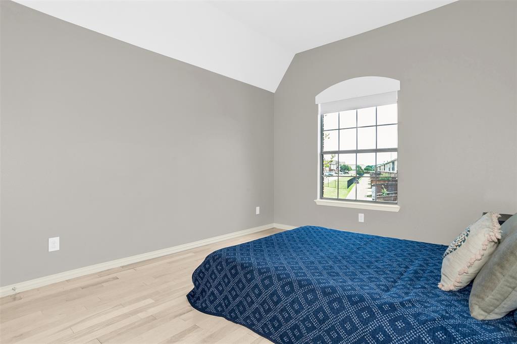 8631 Lohr Valley Road Irving, TX 75063 - Photo 21 of 32 Bedroom featuring light wood-style flooring and vaulted ceiling