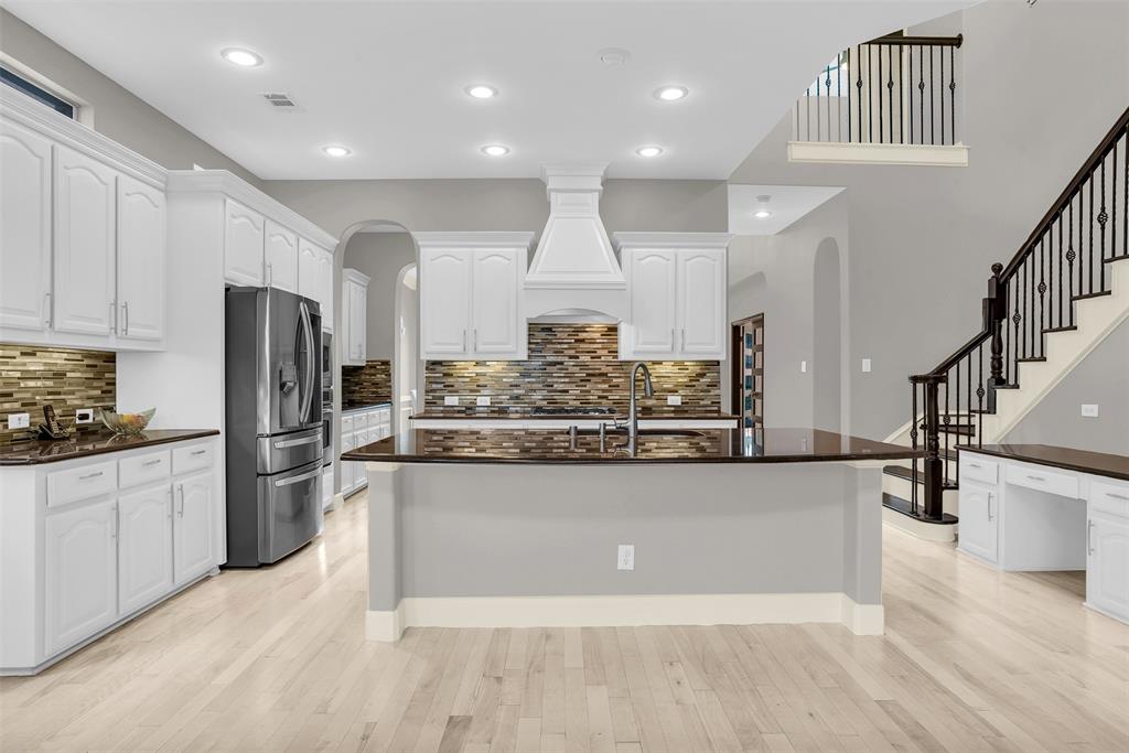 8631 Lohr Valley Road Irving, TX 75063 - Photo 7 of 32 Kitchen featuring arched walkways, white cabinetry, stainless steel appliances, dark stone countertops, and recessed lighting