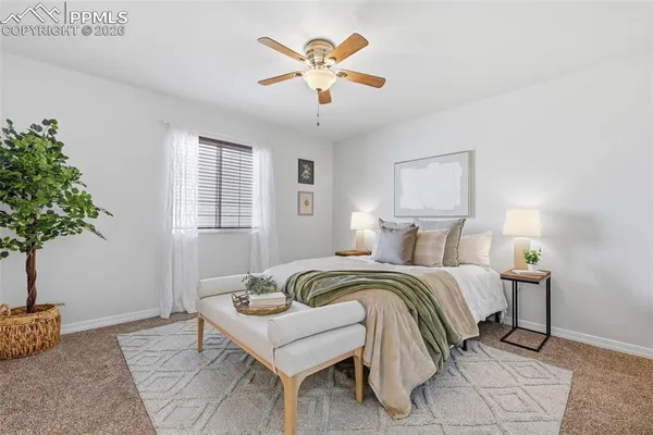 a spacious bedroom with a bed and a potted plant