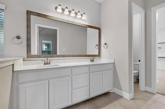 a bathroom with a double vanity sink and a mirror