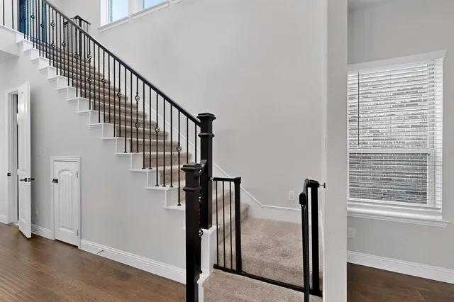 a view of a hallway with wooden floor and staircase