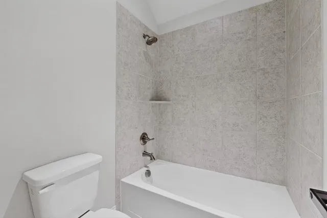 a white bath tub sitting next to a toilet