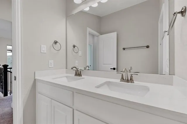 a bathroom with double vanity sinks and a mirror