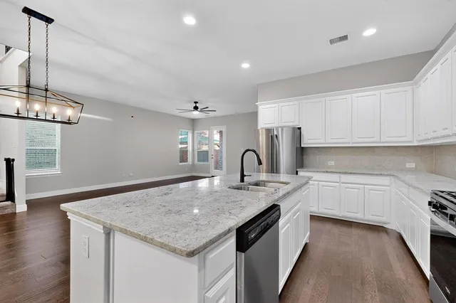 a kitchen with stainless steel appliances granite countertop microwave stove top oven and cabinets