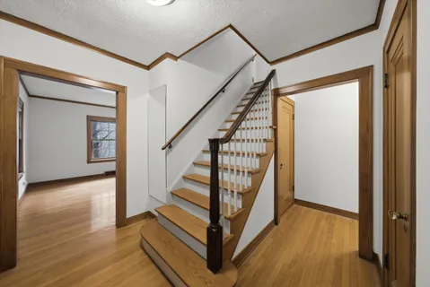 a view of a hallway with wooden floor and staircase